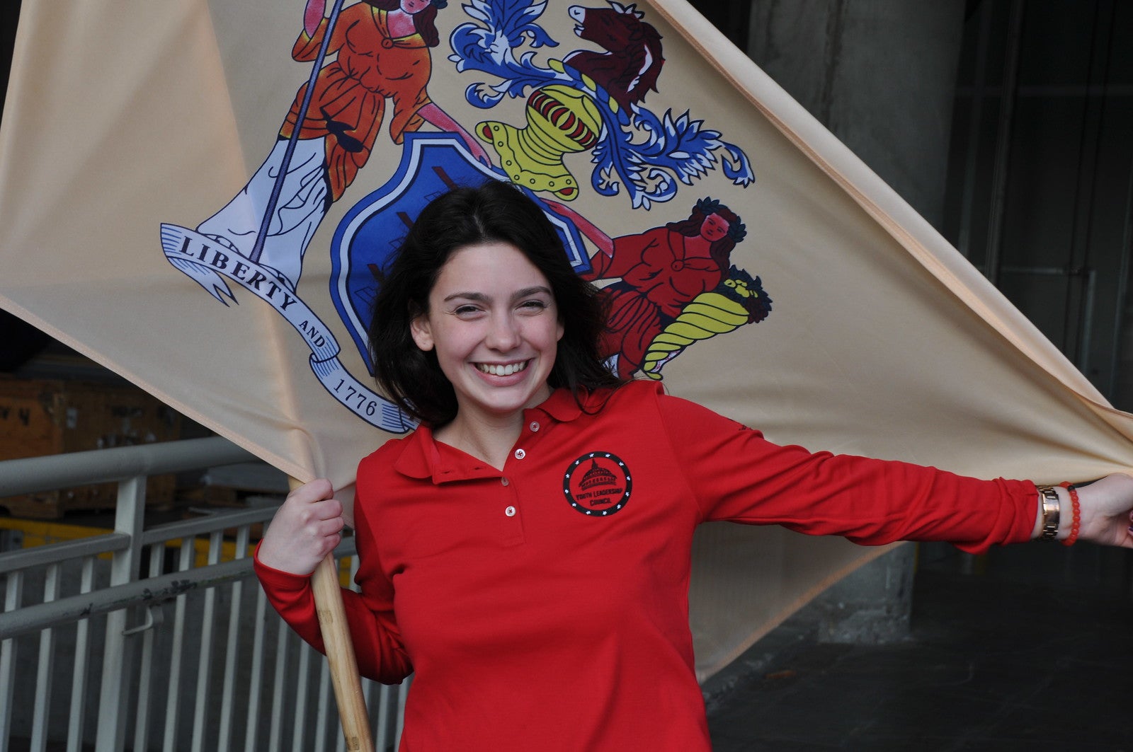 New Jersey Youth Leadership Council student posing with the New Jersey flag