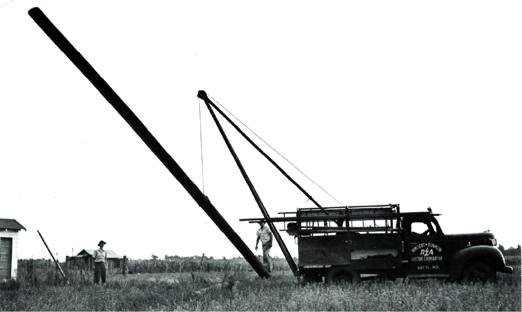 Pemiscot-Dunklin Electric Cooperative workers use a truck’s crane attachment to lift a utility pole into position Source: “The Next Greatest Thing,” published by NRECA