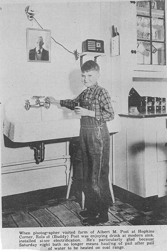 Photo of young boy, Buddy Post, filling up water from a sink. From the Sussex Independent: “When photographer visited farm of Albert M. Post at Hopkins Corner, Roland (Buddy) Post was enjoying drink at modern sink, installed since electrification. He’s particularly glad because Saturday night bath no longer means hauling of pail after pail of water to be heated on coal range.”