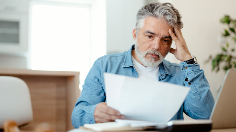 Man looking worriedly at a utility bill