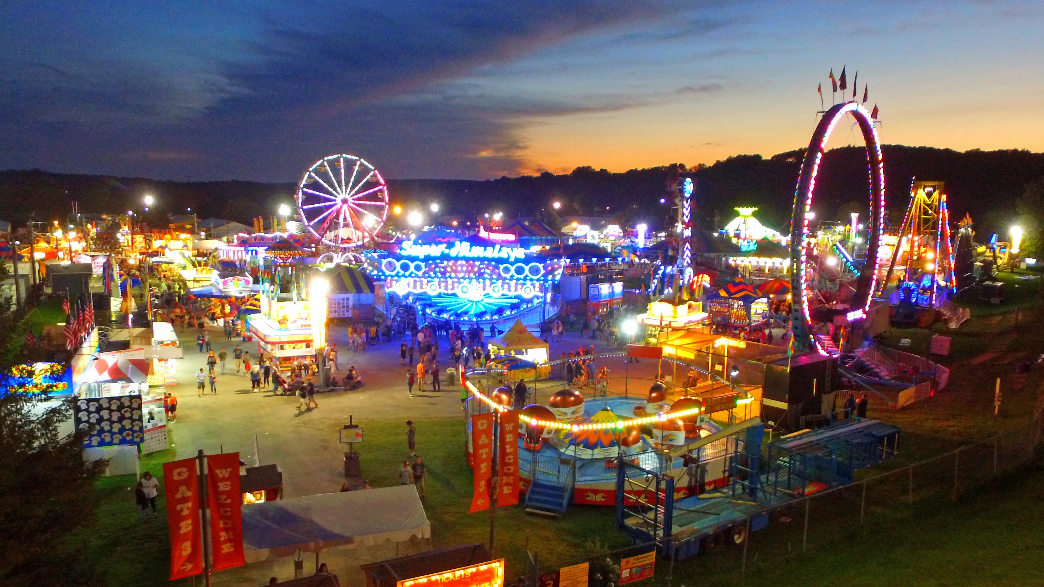 Nighttime photo of the NJ State Fair, illuminated by the rides