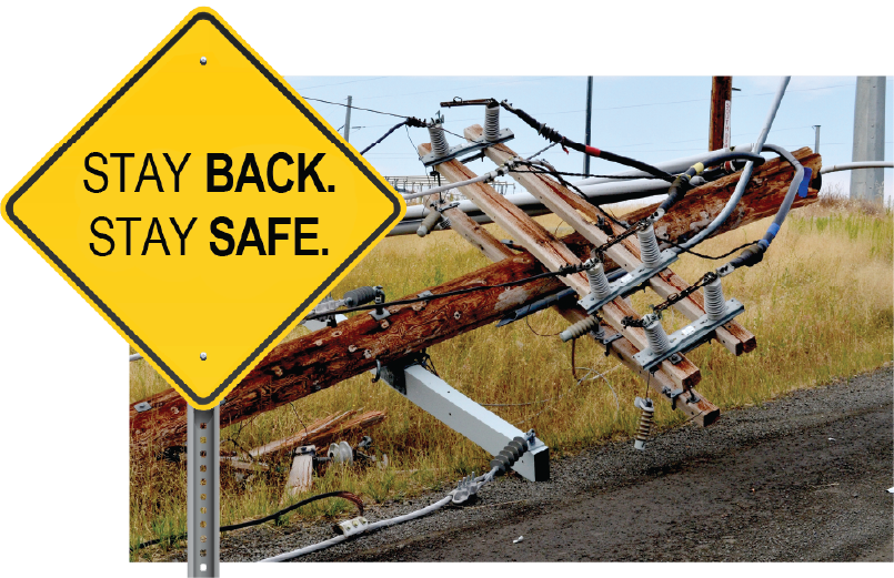 Photo of a utility pole knocked to the ground. A yellow hazard sign pops out of the frame of the image, reading "STAY BACK. STAY SAFE."